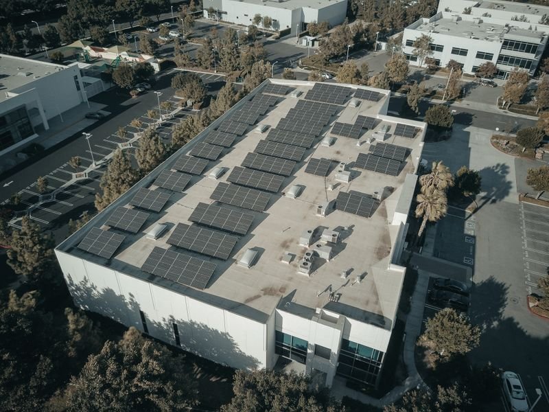 Aerial view of a commercial building with rooftop solar panels