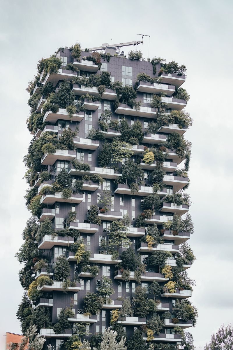 High-rise building facade covered in greenery and planted balconies